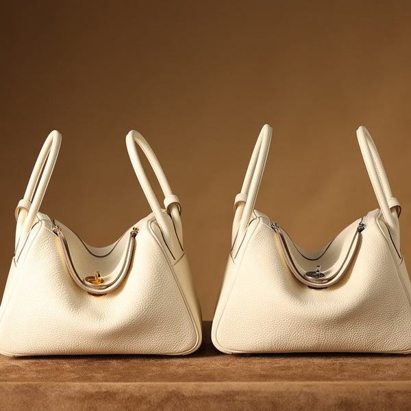 Two pre-owned restored Hermès Lindy bags in ivory with gold and palladium hardware by Empyrean Atelier