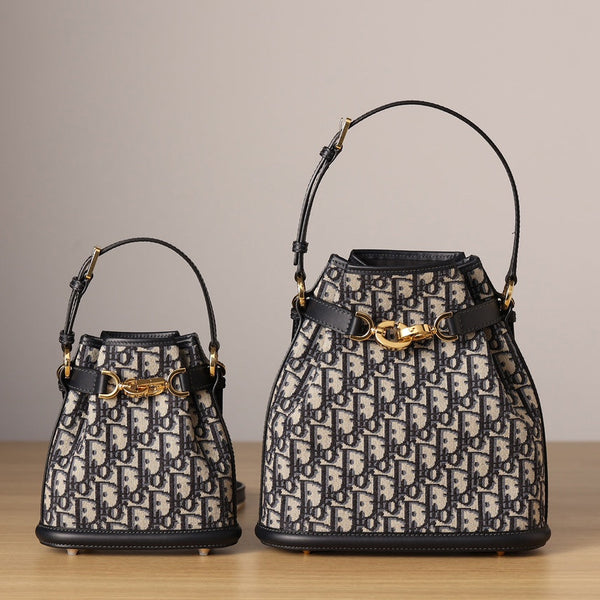 Front view of used restored Dior CD Bucket Bags in two sizes by Empyrean Atelier, featuring navy Oblique canvas, gold-tone hardware, and structured silhouette.