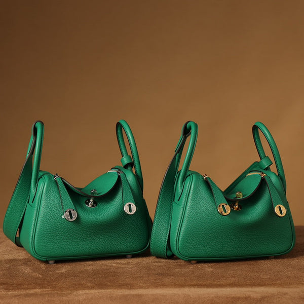 Front view of two restored used Hermès Mini Lindy bags in green Togo leather with gold and silver hardware, artisan-finished by Empyrean Atelier.
