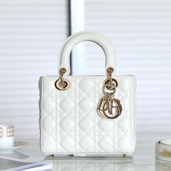Front view of restored used Medium Lady Dior bag in white patent leather with gold hardware and signature Dior letter charm, by Empyrean Atelier.